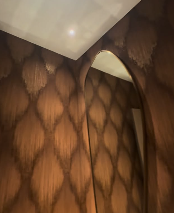 Backlit textured wallcovering with an arched mirror